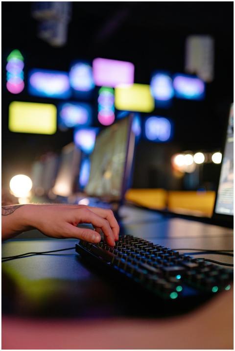 Hand typing on RGB gaming keyboard in a vibrant es