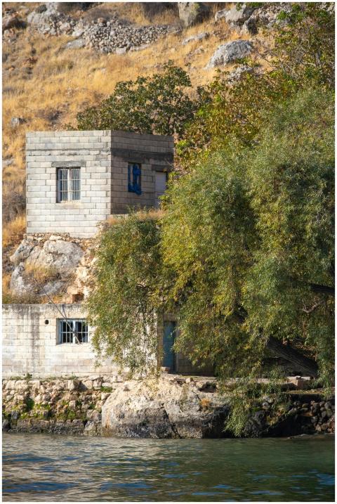 A serene image of an abandoned stone house by the