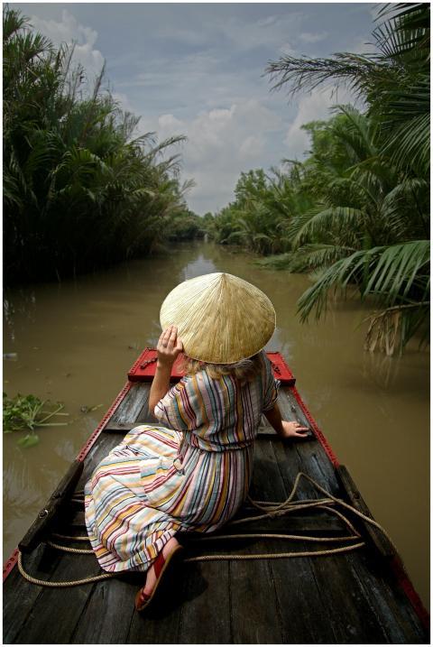 A woman wearing a conical hat navigates through a