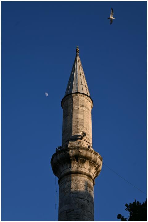 A historic minaret piercing the clear sky, accompa