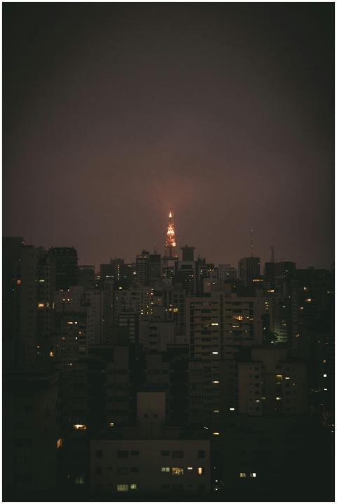Glimpse of an illuminated tower amidst city buildi
