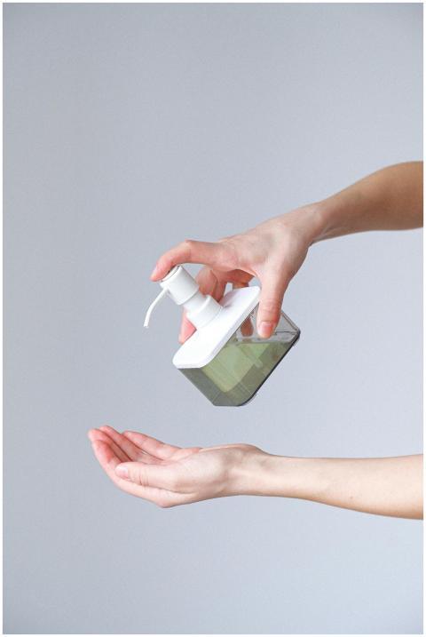 Close-up of a person applying liquid soap for hand