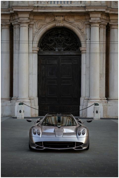 Silver hypercar parked in front of a historic Euro
