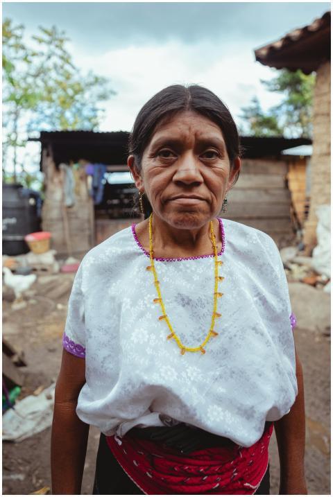 A serious elderly indigenous woman wearing traditi