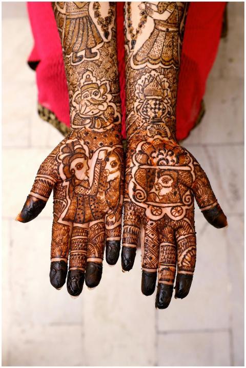 Beautiful mehndi art covers the hands of an adult