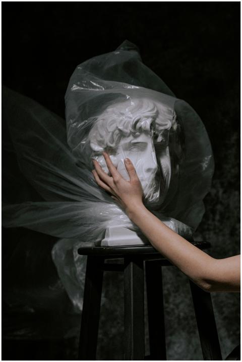 A human hand gently touches a wrapped classical sc