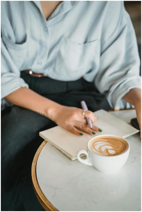 A close-up of a woman writing in a notebook while