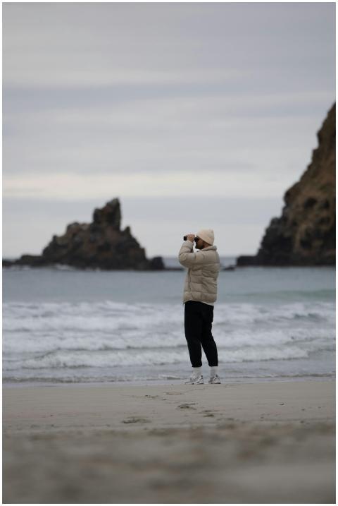 A person captures the rugged beauty of Piha Beach,