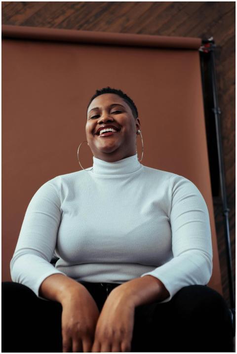 A joyful woman with a short hairstyle smiles confi