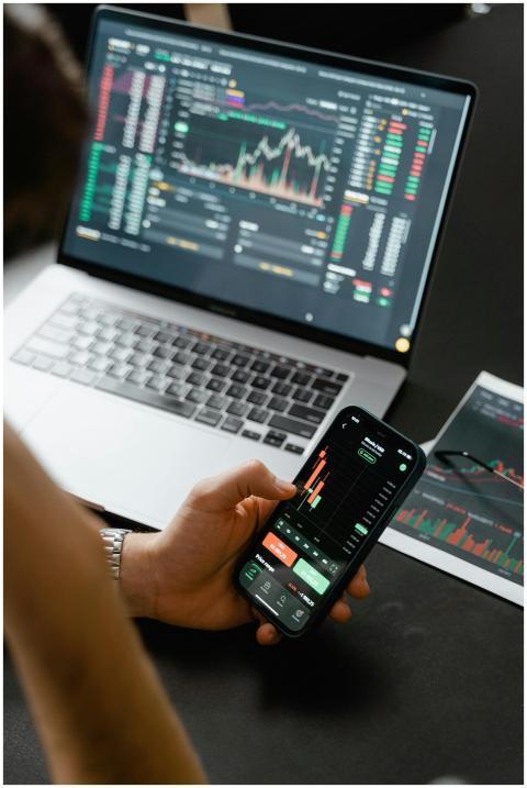 Person analyzing stock market data on a smartphone