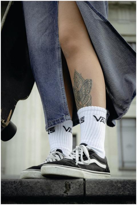 Close-up of a skater's legs in denim and sneakers,