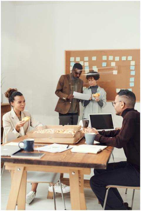 A diverse group of colleagues enjoying a pizza bre