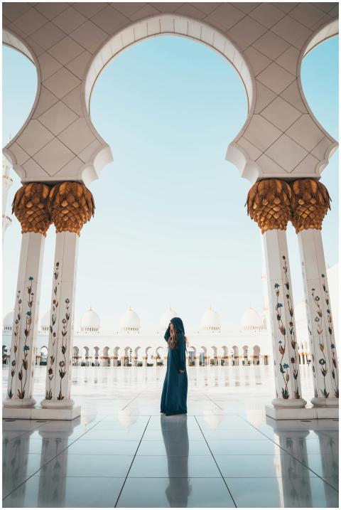 A person in traditional attire standing among colu