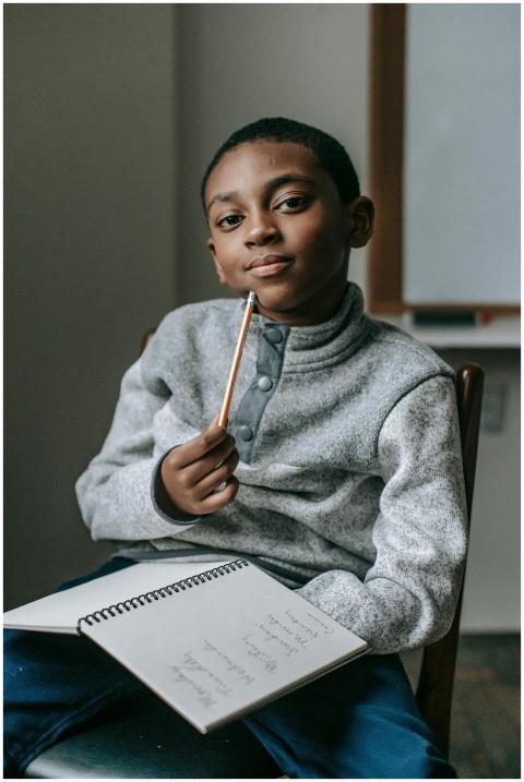 Focused African American boy sitting on chair and