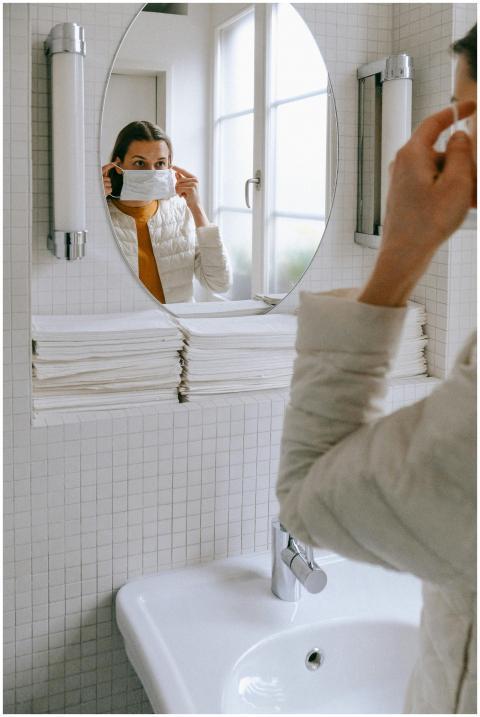 Young woman adjusting her face mask in a bathroom