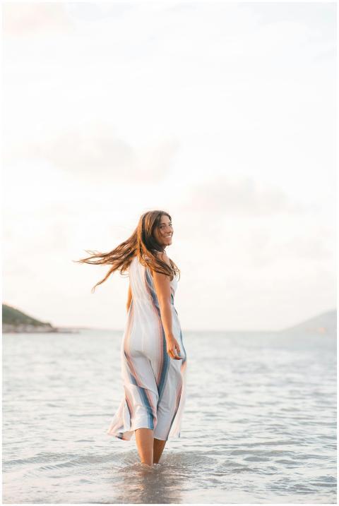 Smiling woman in a dress enjoys a sunny day at the