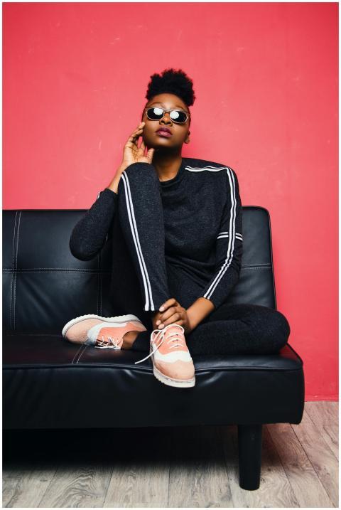 Fashionable woman posing confidently on a sofa in