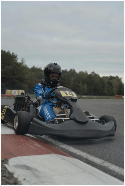 Racer in blue gear maneuvering a go-kart on an out