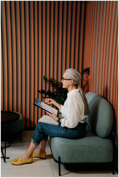 An adult woman in casual attire reviewing notes on