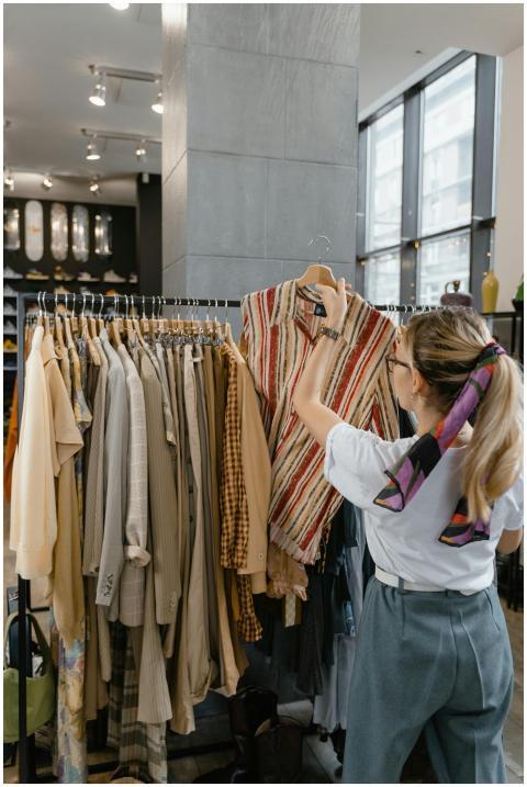 A woman browses clothes on a rack inside a stylish