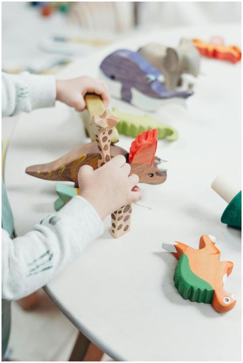 A young child creatively plays with colorful woode