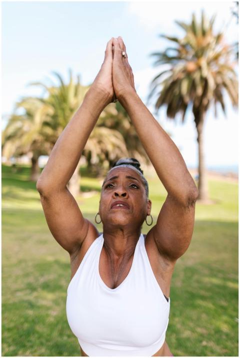 Elderly woman practicing yoga outdoors, embracing