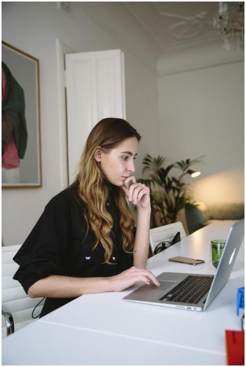 Woman deeply focused on working at a laptop in a s