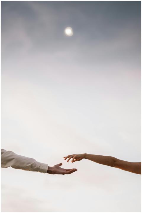 A man and a woman reaching out their hands towards