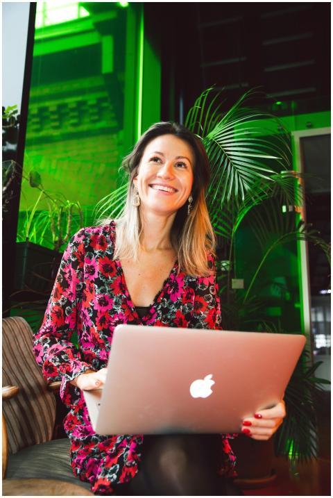 Smiling woman using a laptop in a modern indoor se