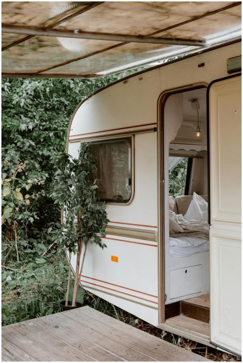 A cozy camper trailer surrounded by lush greenery,