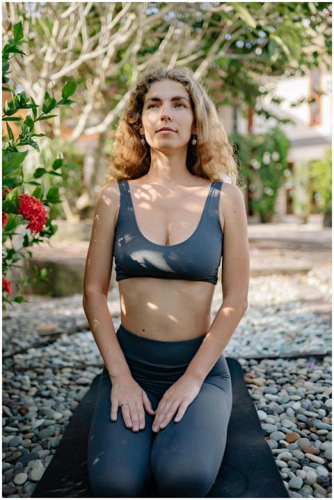 Woman practicing yoga outdoors in lush garden, pro
