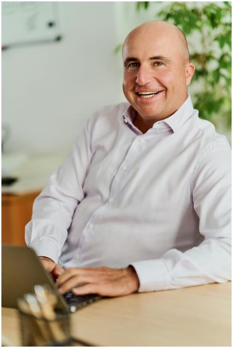 Confident middle-aged businessman smiling at his d