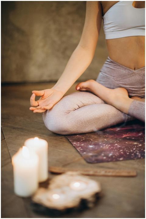 A woman practicing yoga indoors in lotus pose with