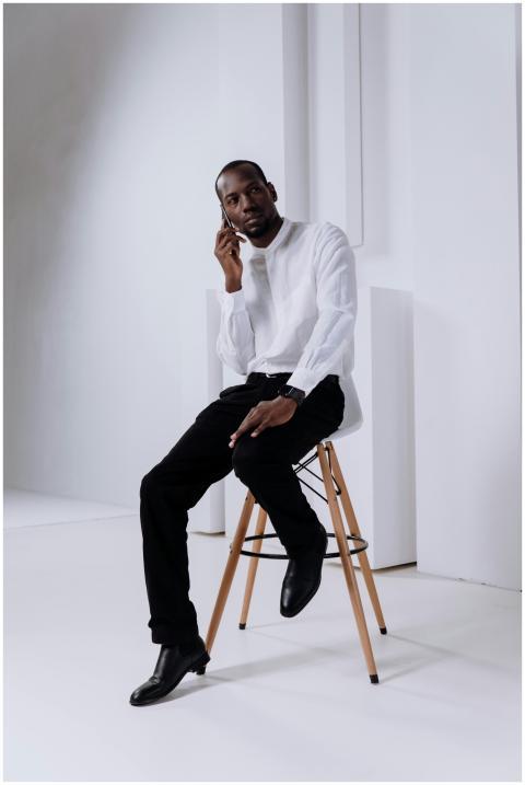 African American man in white shirt on mobile phon