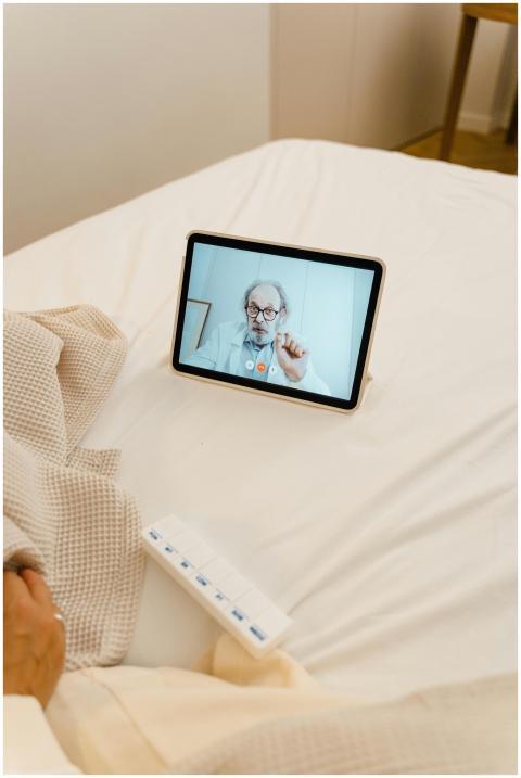 A digital tablet on a bed showing a doctor conduct