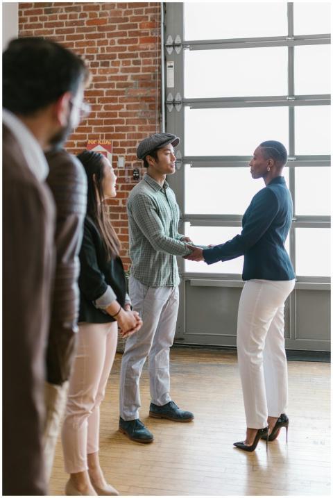 Group of professionals in modern office shaking ha