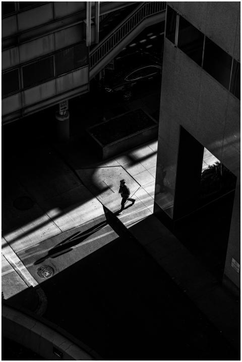 Black and white silhouette of a solitary walker ca