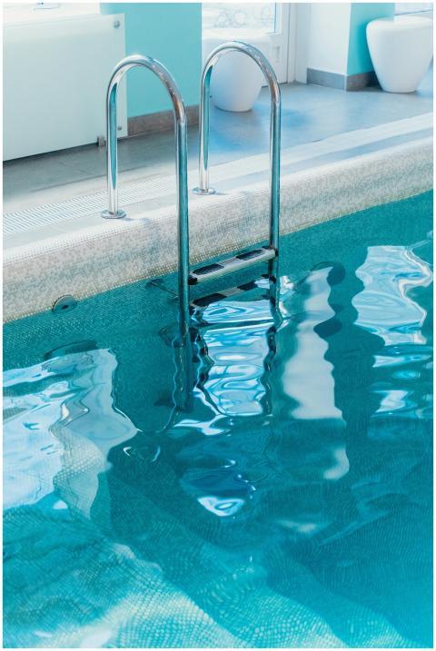 A serene view of an indoor swimming pool with a me