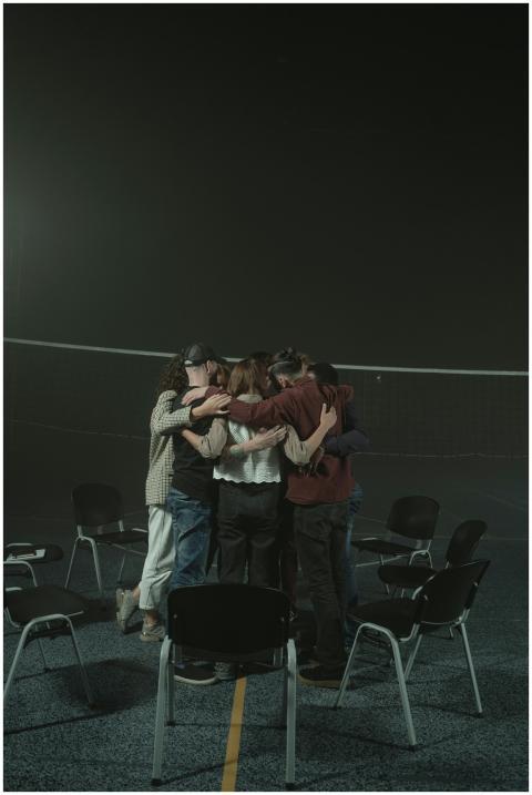 A small group of diverse adults embracing in a sup