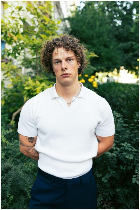 Young man with curly hair posing outdoors in Berli