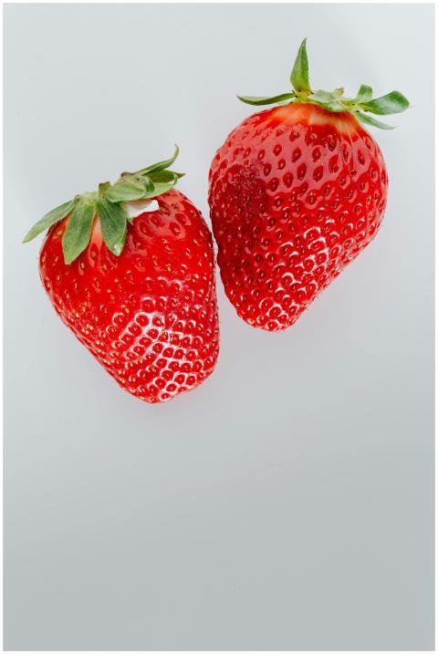 Two ripe strawberries with vibrant red color on a