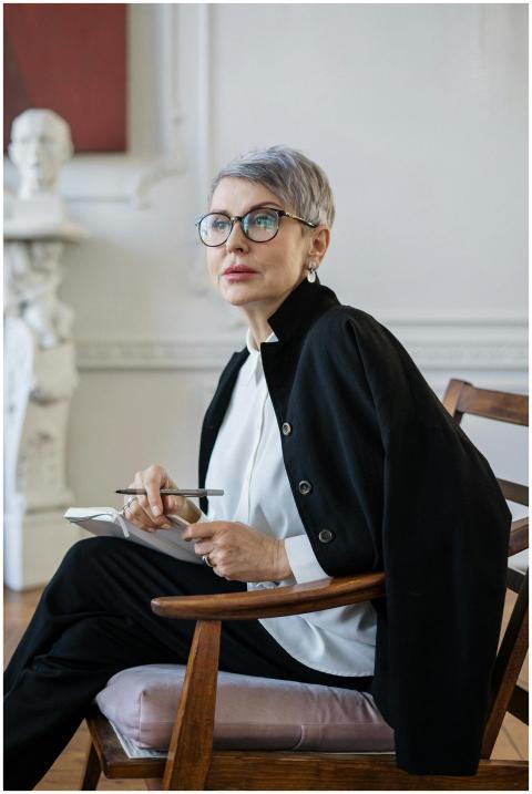 Senior woman with glasses sitting in a stylish off