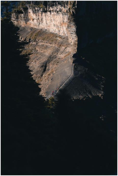 A scenic view of a rugged mountain cliff partially