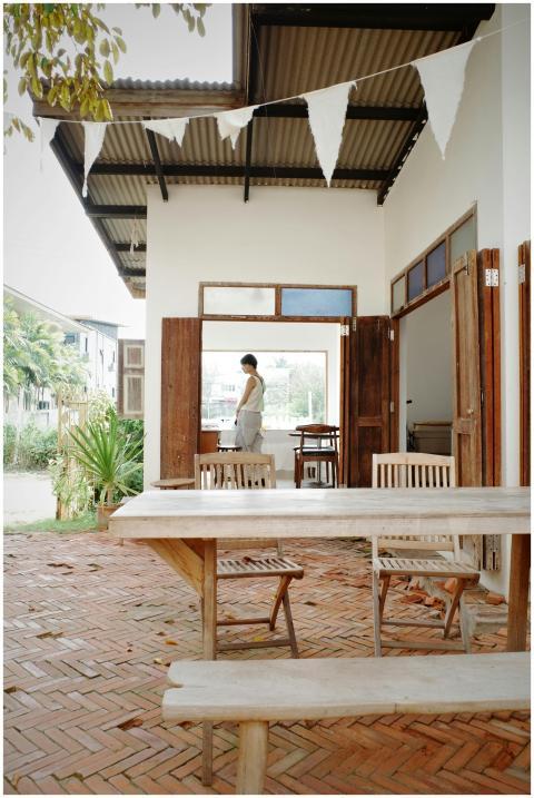 A serene outdoor dining area with wooden furniture