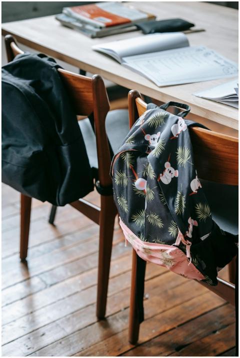 School desk with opened copybooks textbooks and st