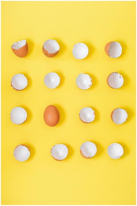 Pattern of whole and cracked brown eggshells on a