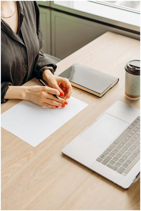 Close-up of a woman's hands with a notebook, coffe