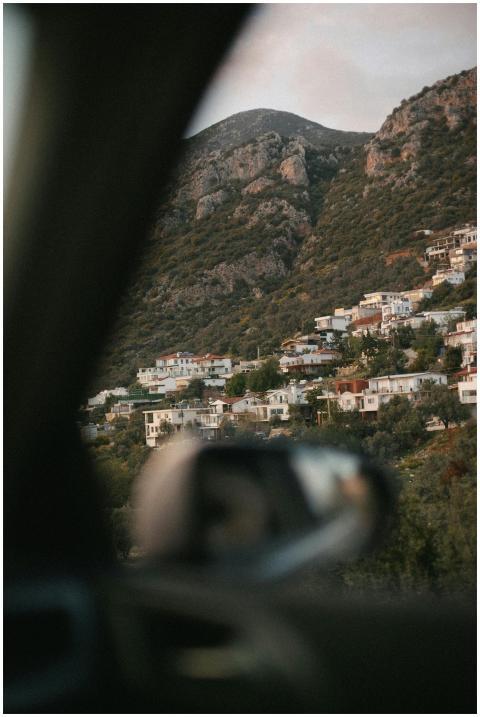 A serene hillside village seen through a car windo