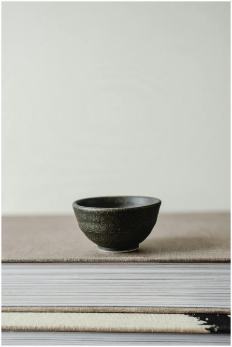 A simple, elegant black ceramic bowl on a stack of