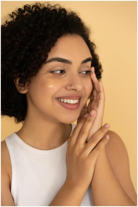 Portrait of a smiling woman gently applying skinca